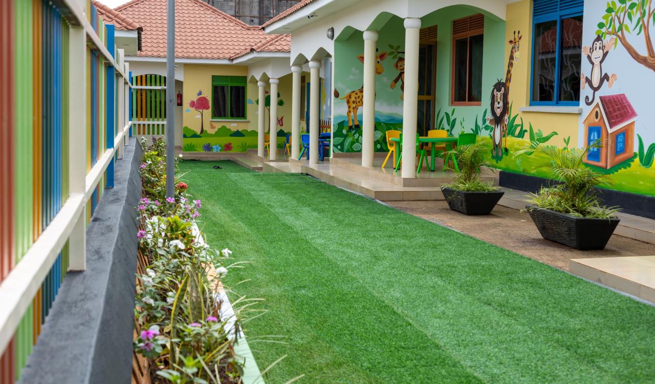 A shaded veranda running beside the lawn and classrooms