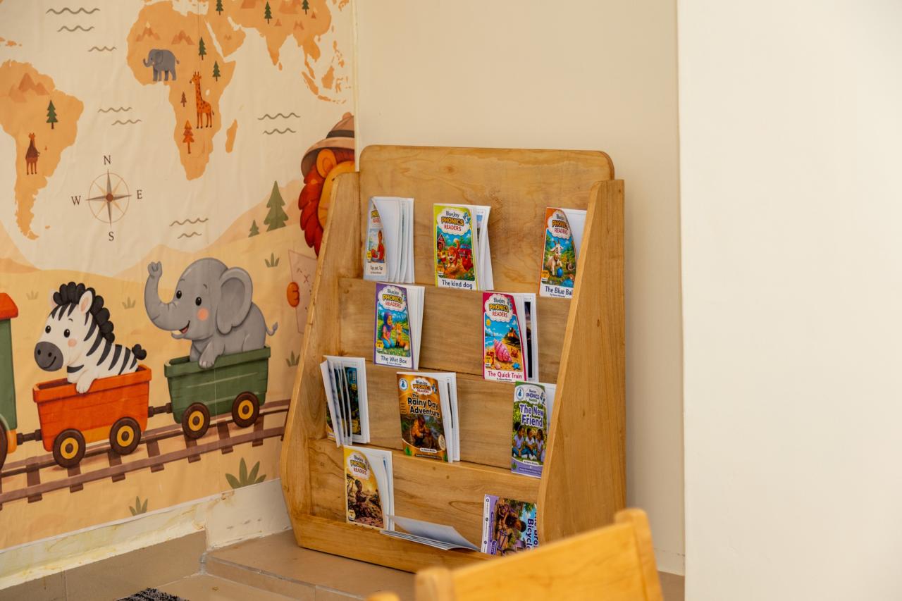 A wall-mounted book display beside a jungle mural