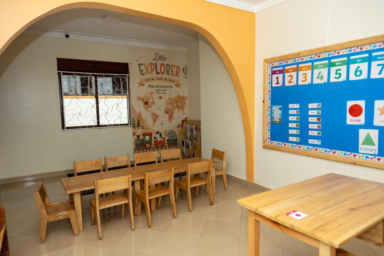 A bright classroom with tables, chairs and a learning board