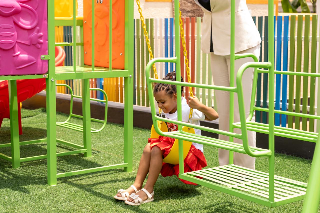 A child on the swing frame in the play garden