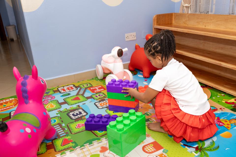 A toddler building with big coloured blocks
