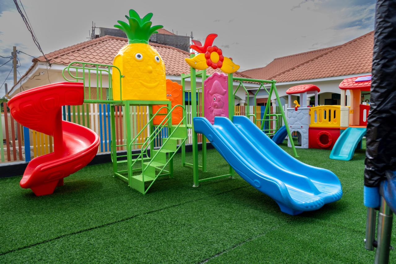 Colourful slides and a pineapple climbing frame in the Little Explorers play garden