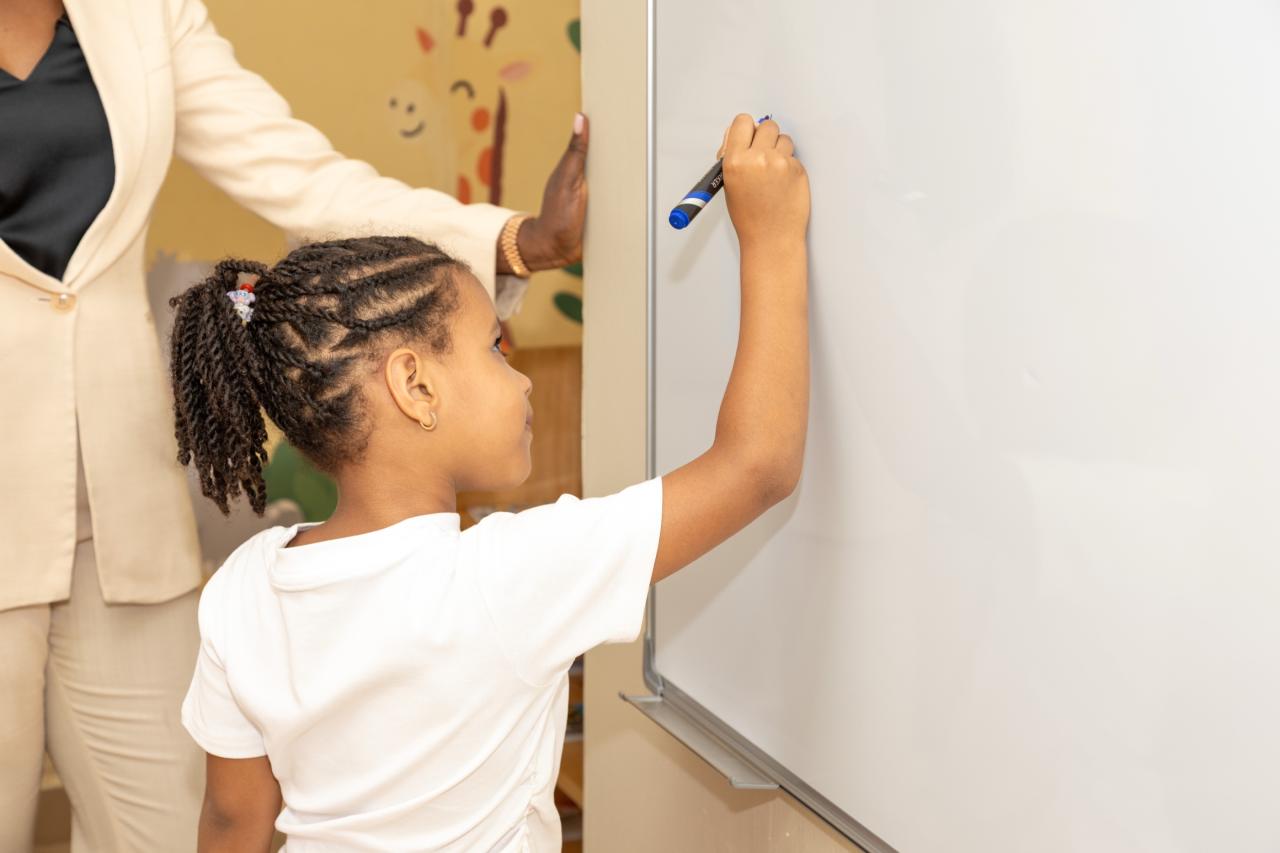A girl writing on the classroom whiteboard