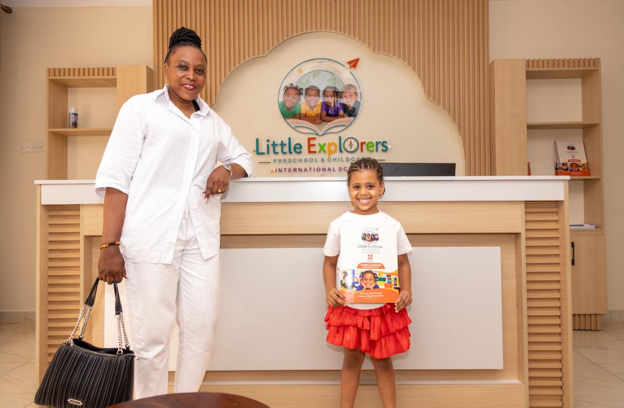 A teacher and child at the Little Explorers reception desk